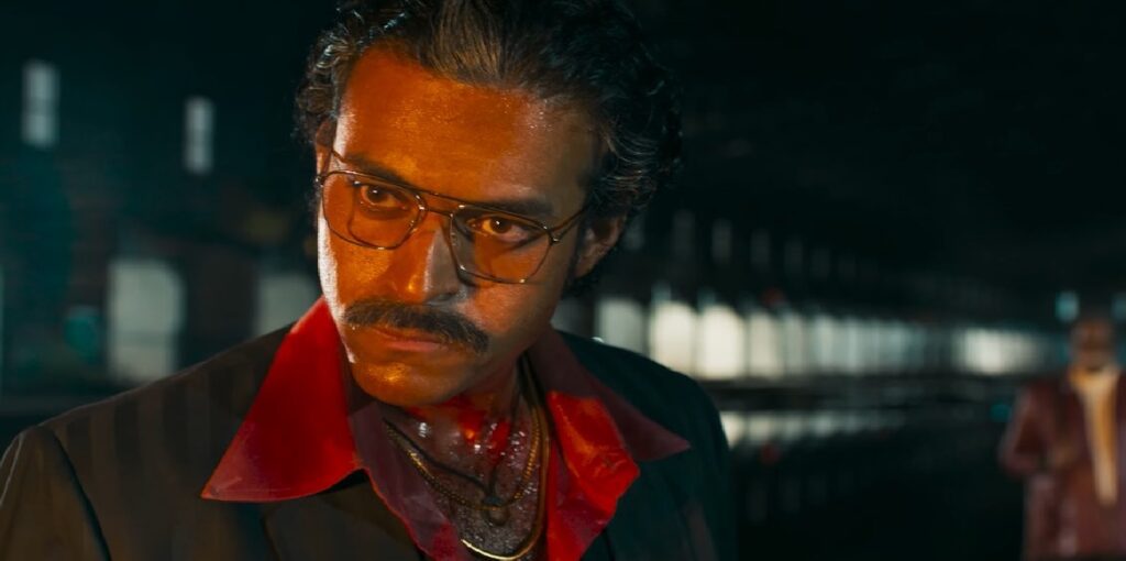 Overview of the Matka Movie Plot and Location Touted as a period drama by its makers, Telugu movie Matka directed by Karuna Kumar treads on the world of gambling and the concept of power. Although in its marketing material it claims to emulate that high time of cinema of late 1950s to early 1980s but rather unfortunately the period drama has pegged its narrative to the height of mediocracy as a simple crime drama. While Varun Tej (who plays ‘Vasu’) is depicted based on an actual person called Ratan Khatri or the ‘Matka King,’ it also glorifies the dark side of the industry of illegal gambling such as its intricacies and hazards, the movie tries too much to advertise gambling. Desperate times led Varun across to the harsh environment of Matka but the film does not settle well with the rest of the actors especially due to weak plot and screenplay. Story Foundation: The Ascent of Vasu as well as the Origins of Matka The character of Vasu, shaped by Ratan Khatri, reflects the complexities of a gambler who has to traverse his way through the maze of illegal betting. Khatri was the first person to popularise the matka betting concept which was fused into a gambling medium that initially originated from the trading of cotton and later turned out to become an important part in Indian economy during the 1970’s. In this case, Karuna Kumar twists the road map of the character from that of a Mumbaikar to a native of Visakhapatnam in order to suit the Telugu film industry. Vasu in Varun Tej’s eyes, a young man who is trying to strike a balance between his existence and the highlife, has a prominent role in the story but the plot, however, does not do much to make his character progress from being a common gambler to an iconic and notorious character. A Predictable Rags-to-Riches Experience CBI officer, played by Naveen Chandra, recounts Vasu’s journey of deception to eventually rising to the top of the underworld in Matka. The portrayal of Vasu as a refugee in the 1950s Burma sung by Kishor Kumar’s black and white cinematography gives depth to the plot. He is seen progressing in life due to his harsh conditions as a child in a juvenile home and being impoverished. These events in a noticeable way are the foundation upon which his later ambitions and picks stand, but the rest of the movie still follows a predictable storyline like it is bound on rails. Supporting Characters: Allies, Enemies And Sequence Breaks Matka is no different as Vasu also meets many of such characters who appear to be an impediment or a progression for him through the film. As Vasu goes through more intense events, the love scene is acted out by Meenakshi Chaudhary as Sujatha, Vasu’s love interest, who performed well despite having less time on-screen. Vasu's feeling is shown by the movie’s romance scenes but the regret in this is that the time used for these was used instead to showing him gambling, a stark contrast on how the character should have been presented. Other supporting characters such as Satyam Rajesh and Ajay Ghosh and John Vijay had minor roles that offered nothing memorable; thus, leaving the audience wishing for more from these alliances and conflicts. When it comes to the underbelly of Visakhapatnam, both politics and crime seem to source out in every attempt one makes to understand it. The film industry has never been scarred by the presence of crime onscreen, in fact Matka seems highly promising and tantalizing due to the political power struggles that the inhabitants of Visakhapatnam tackled whilst coming into the criminal underworld. When trying to sell the film, the creators decided to use ‘a boy from the streets’ trope instead which is devoid of any depth but rather offers the audience a fluff piece that is entertaining as well as fails to offer an insight into the tectonic shift in crime and politics that transpired around the city of Visakhapatnam. This trend seems to not only be inflicted on the people but is apparent in the history of India as well as events like the Emergency and demonetization are treated as mere talking points. Speaking of opportunity, Varun Tej has plenty as he seems to have great command with the part of Vasu. Tej devotes himself to this role, emphasizing Vasu’s awkwardness and later putting on a show of utter confidence, resulting in a tremendous first impression. The tenderness and warmth of Tej Vasus’s eyes captures the stillness and quietness of mind even at its most troubled moments before suddenly exploding out due to external conflicts. However, the idea of him evolving into a more menacing version of himself does not sit comfortably with Rohit. Even though the situation demands one, an attempt by Tej to put on an alluring charm or even a menacing air is limited by the writing. Music, Cinematic Artistry, and the Last Thoughts Matka aospreys itself to tambaram thanks to the Gv prakash kumars music, but unfortunately the richness that is intended is deeply lacking in the film as the songs never seem to fit in the narrative, instead at times throw the tempo of the film off balance. On the other hand, the cinematography by Kishor Kumar is able to create an aura by using retro visuals and imagery which helps in knitted viewers to a different time period. Despite this, the narrative is full of good opportunities that were squandered, the pre climax and climax, and plot twists and character revelations were all unsurprising, therefore the pathos of the film did not have the desired magnitude. For the followers of crime drama and biographies, Matka makes them feel as if they are watching a half-baked version of a very popular genre. Conclusion: A captivating story with an attempt to be creative but fell flat Matka, while trying to tell the morally ambiguous story of an Indian Gambler does not push to deliver something that is remarkable or worth its meaning. Despite the films great set pieces and period accuracy or even Varun Tej's honest performance, it is held back by a poorly written plot and poorly developed characters. Matka will be disappointing to most who wish to watch gripping and cerebral crime films as the film fails to go beyond the very basic and shallow aspects of the genre.