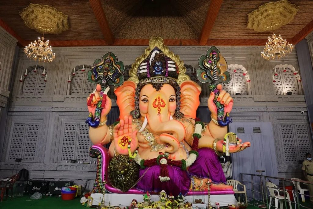 The majestic spectacle of Balapur Ganesh Utsav 2025 promises to be an extraordinary spiritual experience that transcends the boundaries of devotion and artistry. This year's celebration has captured national attention with its breathtaking theme – a meticulously crafted replica of the renowned Swarnagiri Venkateswara Swamy temple near Yadadri. As someone who has witnessed countless Ganesh celebrations across India over the past decade, I can confidently say that Balapur's 2025 mandap represents a pinnacle of cultural heritage and artistic excellence that will leave an indelible mark on every visitor's heart. What makes this year's celebration truly special isn't just the architectural grandeur, but the profound spiritual symbolism embedded in every detail. The Balapur Ganesh festival has evolved from a humble community gathering in 1994 to become one of India's most celebrated religious events, attracting millions of devotees from across the globe. The transformation from a modest ₹450 laddu auction to the record-breaking ₹30.01 lakh bid in 2024 tells a remarkable story of faith, community spirit, and divine blessings. The Magnificent Swarnagiri Temple Replica: Where Divine Architecture Meets Devotion Walking into the Balapur mandap this year feels like stepping into a sacred realm where earthly craftsmanship mirrors celestial beauty. The Swarnagiri Venkateswara Swamy temple replica stands as a testament to the extraordinary skills of artisans from Shamirpet and Dilsukhnagar, who dedicated over a month of continuous work to bring this vision to life. Kellam Niranjan Reddy, president of the Balapur Ganesh Utsav Samithi, explains that the intricate Jala Narayana Swamy installation mirrors the original temple's design with remarkable precision. The original Swarnagiri temple, located on the picturesque Manepally Hills just 47.3 kilometers from Hyderabad, represents a magnificent fusion of architectural styles from the Pallava, Vijayanagara, Chola, and Chalukya dynasties. This ₹500 crore architectural marvel, built over seven years on a sprawling 22-acre property, houses Telangana's largest Venkateswara Swamy idol at 12 feet tall. The Balapur artisans have captured this grandeur through innovative fiber work, creating a mandap that showcases four Rajagopurams leading to spacious halls and a five-story Vimana Gopuram above the sanctum sanctorum. What struck me most during my recent visit was the attention to detail in recreating the temple's signature elements. The fiber construction allows for intricate carvings and decorative elements that would be impossible with traditional materials, while maintaining the structural integrity needed to accommodate thousands of daily visitors. The lighting system, carefully designed to illuminate the mandap during evening hours, creates an almost ethereal atmosphere that transforms the entire space into a divine sanctuary. Behind the Scenes: The Artistry and Dedication That Defines Excellence The creation of this magnificent replica represents one of the most ambitious undertakings in recent Hyderabad Ganesh pandal history. Despite challenging weather conditions, including the heavy rains that have characterized this monsoon season, the construction team worked tirelessly to complete the project. The commitment shown by these artisans reflects the deep spiritual connection that drives the entire Balapur community. Sudhakar Reddy, who leads the team of artisans responsible for the Swarnagiri replica, brings decades of experience in temple architecture and festival decoration. His team's expertise in fiber work allows them to create structures that are both visually stunning and practically sound. The fiber temple setup technique they've pioneered enables the creation of intricate architectural details while ensuring the mandap can withstand the physical demands of hosting hundreds of thousands of visitors over the 10-day festival period. The construction process began with detailed study of the original Swarnagiri temple's architectural plans and photographic documentation. Every element, from the smallest decorative motif to the grandest architectural feature, was carefully measured and replicated. The team worked in shifts, maintaining progress even during the heaviest downpours that have marked this year's monsoon season. This dedication to authenticity extends beyond mere visual similarity. The artisans have incorporated traditional construction techniques wherever possible, using modern materials like fiber only where they enhance durability and safety. The result is a structure that honors the original temple's spiritual essence while meeting the practical requirements of a major public festival. Sacred Iconography: The Divine Presence of Multiple Deities The spiritual significance of this year's Balapur celebration extends far beyond its architectural magnificence. The mandap houses not only the traditional 21-foot Ganesh idol seated regally on a diwan but also includes representations of Anantha Padmanabha Swamy and Venkateswara Swamy. This unique combination creates a powerful spiritual atmosphere that resonates with devotees from diverse Hindu traditions. The inclusion of Anantha Padmanabha Swamy, the form of Lord Vishnu reclining on the serpent Adi Sesha, adds profound theological depth to the celebration. This deity, particularly revered in Kerala's Padmanabhaswamy Temple, represents the eternal, infinite nature of divine consciousness. The careful placement of this idol alongside Lord Ganesha creates a spiritual dialogue between different aspects of Hindu devotional practice. Above the main Ganesh idol, artisans have placed the face of Lord Shiva, symbolizing the unity of the Hindu trinity and the interconnected nature of divine energy. This innovative design element transforms the traditional Ganesh celebration into a comprehensive spiritual experience that acknowledges the full spectrum of Hindu theological understanding. The floral decoration Ganesh Chaturthi elements throughout the mandap include traditional toranas made from fresh flowers, with particular emphasis on marigolds, roses, and jasmine that are considered especially sacred to Lord Ganesha. These decorations are refreshed daily by dedicated volunteers, ensuring that the visual and aromatic experience remains vibrant throughout the festival period. The Legendary Balapur Laddu Auction: A Tradition of Faith and Fortune No discussion of Balapur Ganesh Utsav would be complete without examining the extraordinary tradition of the laddu auction, which has become a cultural phenomenon extending far beyond Hyderabad's boundaries. The journey from ₹450 in 1994 to ₹30.01 lakh in 2024 represents more than mere inflation – it reflects the growing faith in the transformative power of this sacred prasadam. The story begins with Kolan Mohan Reddy, a humble farmer who made the first successful bid in 1994. According to local legend, after winning the auction, Mohan Reddy distributed portions of the laddu to his family and then sprinkled the remaining prasadam on his farmland. The subsequent bumper harvest convinced the community that the Balapur laddu possessed extraordinary spiritual power, establishing a tradition that continues to this day. The 2024 auction, won by Kolan Shankar Reddy for ₹30.01 lakh, demonstrates the enduring appeal of this tradition. The 21 kg Balapur laddu, prepared with pure ghee, milk instead of water, and enriched with premium dry fruits, represents the pinnacle of devotional offering. The auction process itself has evolved into a carefully orchestrated event, with participants required to deposit the previous year's winning amount in advance to qualify for bidding. The September 6, 2025 auction promises to be particularly significant, with Chief Minister A Revanth Reddy invited to attend the ceremony. This high-level political participation reflects the auction's evolution from a local community event to a matter of state-wide importance. The proceeds from the auction continue to fund community development projects, including temple renovations, CCTV installations, educational initiatives, and infrastructure improvements throughout the Balapur area. Crowd Management and Safety: Ensuring Divine Experiences for All The massive popularity of Balapur Ganesh festival necessitates sophisticated crowd management strategies that balance accessibility with safety. The organizers have implemented comprehensive measures including strategic barricading, multiple entry and exit points, and coordination with local police forces to ensure smooth movement of the hundreds of thousands of expected visitors. The Ganesh Chaturthi Hyderabad events require special attention to weather-related challenges this year, as the IMD has issued warnings for continued rainfall throughout the festival period. Heavy rains have already begun affecting the city, with Hyderabad receiving significant precipitation on the festival's opening day. These conditions require additional safety measures, including covered walkways, non-slip flooring materials, and enhanced drainage systems around the mandap. Police guidelines for 2025 emphasize several critical safety protocols. Organizers must deploy volunteers with proper identification cards around the clock to manage queues and assist with security checks. Emergency equipment, including fire safety apparatus, sand bags, and water drums, must be readily available at all times. The mandap is equipped with CCTV cameras providing comprehensive coverage and real-time monitoring capabilities. Visitors should plan their trips carefully, considering both weather conditions and crowd patterns. Morning visits typically offer better safety conditions for families with children, while evening visits provide the full impact of the mandap's lighting design. The organizers recommend avoiding peak hours (typically 6-10 PM) unless visitors are prepared for extended waiting periods and crowded conditions. Community Spirit and Cultural Heritage: The Heart of Celebration The true magic of Balapur Ganesh Utsav lies not in its spectacular visual elements but in the extraordinary community participation that makes the festival possible. Youth volunteers from across Hyderabad contribute thousands of hours of service, managing everything from crowd control to decoration maintenance. Senior citizens share their decades of festival experience, ensuring that traditional practices are preserved while embracing innovative improvements. The cultural heritage mandap themes have evolved over the years to reflect contemporary spiritual interests while maintaining connection to classical Hindu traditions. Previous themes have included the Ayodhya Ram Mandir (2024), Vijayawada Kanaka Durga Temple (2023), and Yadadri temple designs. Each year's theme selection involves extensive community consultation and careful consideration of both artistic possibilities and spiritual significance. Women play crucial roles in the festival's success, particularly in the preparation of traditional offerings and the maintenance of ritual purity throughout the celebration period. The preparation of modaks, the sweet offering traditionally associated with Lord Ganesha, becomes a community-wide activity involving families across the Balapur area. These traditional sweets are prepared using recipes passed down through generations, maintaining authentic flavors and spiritual significance. The involvement of artisan communities from across Telangana creates economic opportunities that extend far beyond the festival period. The skills developed for Ganesh mandap construction are later applied to wedding decorations, corporate events, and other cultural celebrations, creating year-round employment for specialized craftspeople. Weather Considerations and Visitor Guidelines for 2025 The 2025 Ganesh Chaturthi celebrations coincide with an active monsoon period that requires careful planning from both organizers and visitors. The India Meteorological Department has issued yellow alerts for Hyderabad and surrounding districts, predicting continued rainfall through early September. These conditions create both challenges and opportunities for festival participants. The rain adds a mystical quality to the celebration, with the sound of droplets on the mandap's tarpaulin roof creating a natural percussion accompaniment to devotional chanting. However, visitors must take appropriate precautions including waterproof footwear, umbrellas, and protective covering for electronic devices. The organizers have installed additional lighting to compensate for reduced natural illumination during overcast conditions. Transportation to and from the festival site may be affected by waterlogged roads and increased traffic congestion. Visitors should allow extra travel time and consider using public transportation where possible. The TGSRTC has deployed additional buses and maintenance personnel to handle increased demand and potential weather-related breakdowns. Safety considerations become particularly important during wet conditions. The mandap's flooring has been treated with anti-slip materials, and additional handrails have been installed at key points. Visitors are advised to move slowly and carefully, particularly in areas where large crowds gather for darshan. Looking Beyond 2025: The Future of Balapur Ganesh Celebrations The success of this year's Swarnagiri temple replica sets new standards for future celebrations and demonstrates the community's commitment to continuous innovation within traditional frameworks. The techniques developed for fiber construction will likely influence pandal design across India, offering new possibilities for creating elaborate temporary structures that rival permanent architecture in their visual impact. The environmental implications of using fiber instead of traditional materials deserve consideration as the festival industry grapples with sustainability concerns. While fiber construction reduces the need for large quantities of wood and other natural materials, it raises questions about long-term disposal and recycling. The Balapur organizers are exploring partnerships with manufacturing companies to repurpose mandap materials for commercial applications after the festival. The growing recognition of Balapur Ganesh as a national cultural symbol opens possibilities for international participation and cultural exchange programs. Several overseas Indian communities have expressed interest in creating scaled replicas of Balapur's designs for their own celebrations, potentially spreading Telangana's cultural influence to global Indian diaspora communities. The integration of technology, including drone photography for promotional materials and digital payment systems for donation collection, points toward a future where traditional celebrations embrace modern conveniences while preserving their essential spiritual character. The committee is exploring virtual reality applications that could allow remote participation for devotees unable to visit in person. Conclusion: A Celebration That Transforms Hearts and Communities The Balapur Ganesh Utsav 2025 represents far more than a religious festival – it embodies the transformative power of collective devotion, artistic excellence, and community solidarity. The magnificent Swarnagiri temple replica serves as a bridge between earthly craftsmanship and divine inspiration, creating sacred space where millions of hearts unite in celebration of Lord Ganesha's benevolent presence. As we witness the continued evolution of this remarkable tradition, from its humble beginnings with a ₹450 laddu auction to today's spectacular architectural achievements, we see reflected the very qualities that Lord Ganesha represents: the removal of obstacles, the blessing of new beginnings, and the triumph of wisdom over ignorance. The dedication of countless volunteers, the skill of master artisans, and the unwavering faith of devotees combine to create an experience that transcends the boundaries between sacred and secular, traditional and innovative. Whether you come seeking spiritual solace, artistic inspiration, or simply the joy of participating in one of India's grandest celebrations, the Balapur Ganesh Utsav offers a transformative experience that will resonate long after the final immersion ceremony. In the words whispered by countless devotees as they depart: "Ganapati Bappa Morya, Pudhchya Varshi Lavkar Ya" – may Lord Ganesha return next year with even greater blessings for all who seek his divine grace. Frequently Asked Questions Q: What are the visiting hours for Balapur Ganesh Utsav 2025? The mandap remains open 24/7 throughout the festival period (August 27 - September 6, 2025) for free darshan. However, for the best experience with manageable crowds, visit during morning hours (6 AM - 10 AM) or late evening (after 10 PM). The lighting effects are particularly spectacular after sunset, making evening visits ideal for photography enthusiasts. Q: How can I participate in the famous laddu auction on September 6, 2025? To participate in the Balapur laddu auction, you must register in advance by paying a deposit equal to the previous year's winning amount (₹30.01 lakh for 2025). Registration requires submission of identification documents and the deposit must be paid in cash or bank transfer one day before the auction. The auction begins around 10 AM on September 6, following the morning procession through Balapur village. Q: What safety precautions should visitors take given the current weather conditions? With heavy rains predicted throughout the festival period, visitors should wear waterproof footwear, carry umbrellas, and dress in quick-dry clothing. The mandap has anti-slip flooring and adequate drainage, but extra caution is advised in crowded areas. Avoid touching electrical installations and stay away from temporary structures during lightning. Keep electronic devices in waterproof covers and allow extra travel time due to potential traffic delays from waterlogged roads