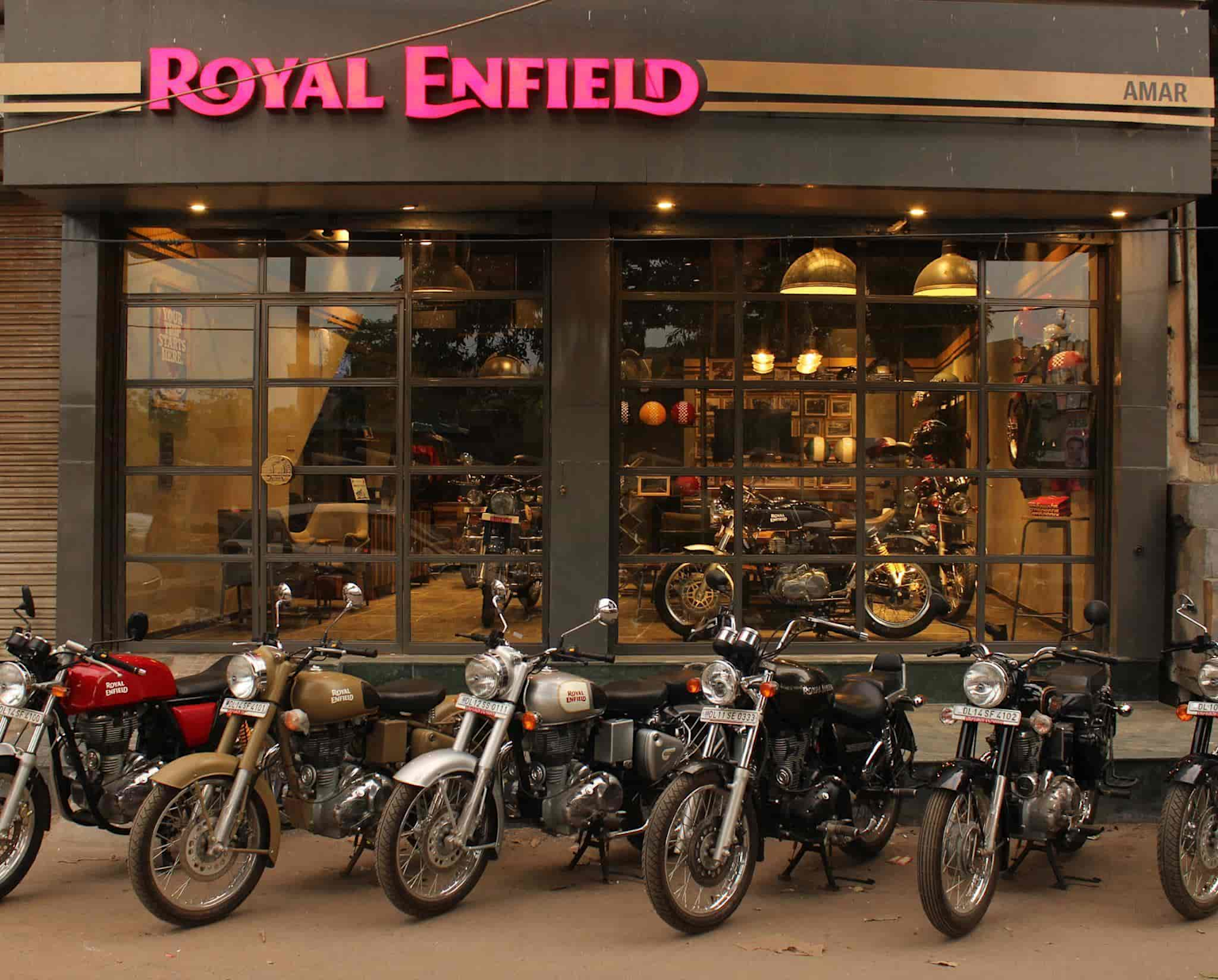Royal Enfield motorcycle dealership showcasing multiple models in front of a well-lit showroom in India