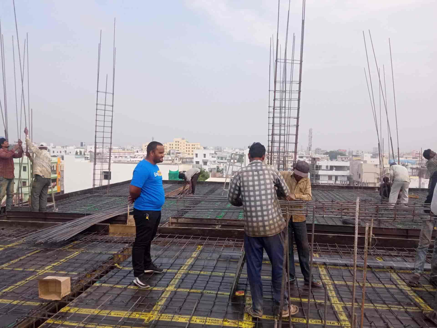 Workers reinforcing steel bars at a construction site representing infrastructure development relevant to Medaram works