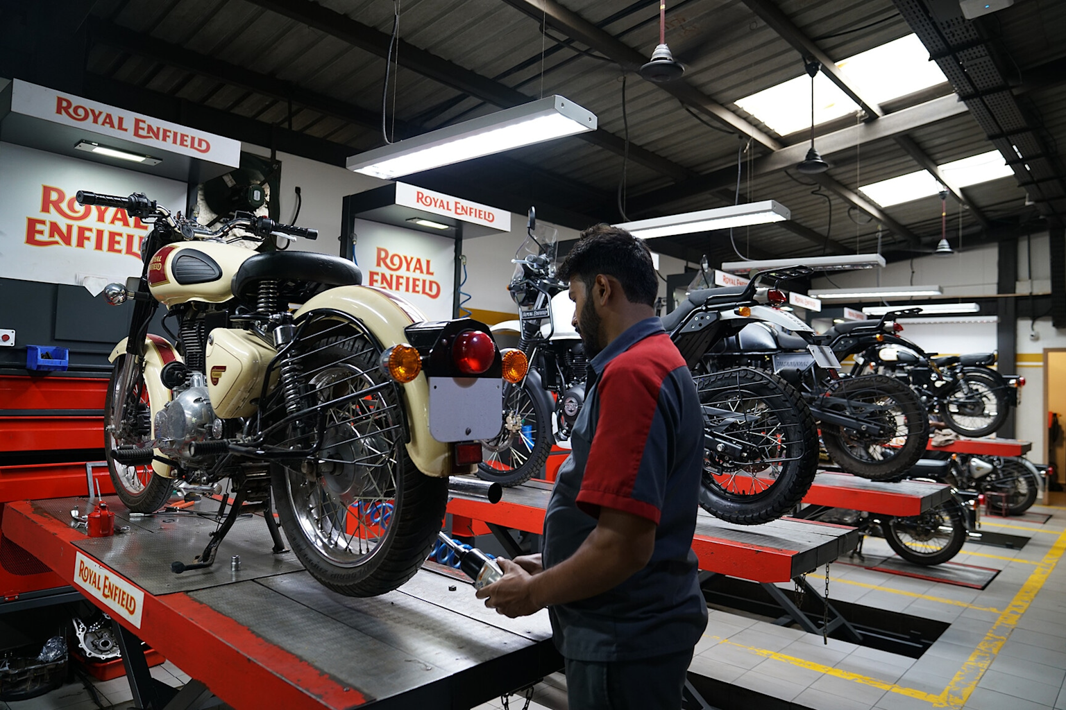 Royal Enfield motorcycles undergoing maintenance in an authorized showroom service area in India